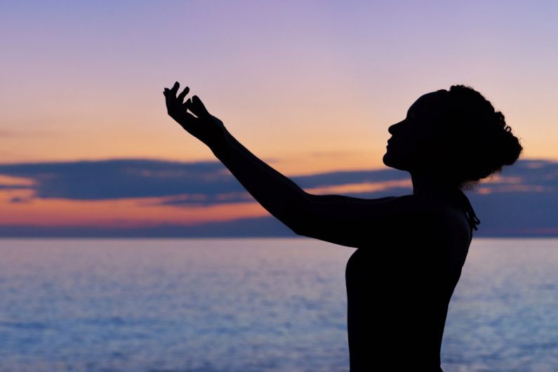 Wellness - silhouette of woman raising her right hand