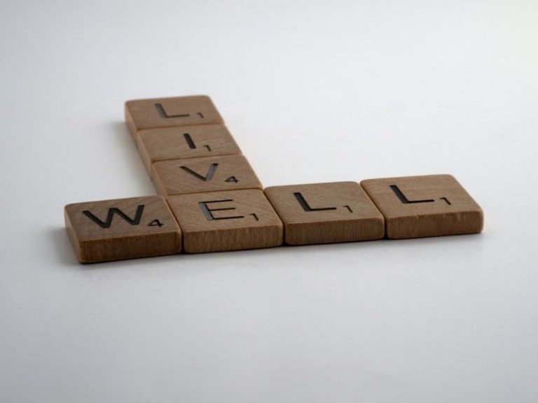 Wellness - brown wooden letter blocks on white surface