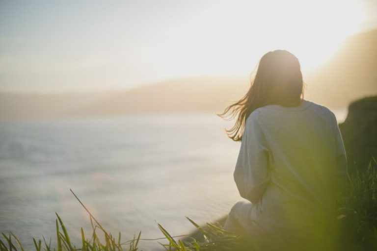 Wellness - woman wearing gray long-sleeved shirt facing the sea