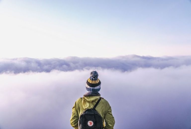 Traveler - person looking thru sea of clouds