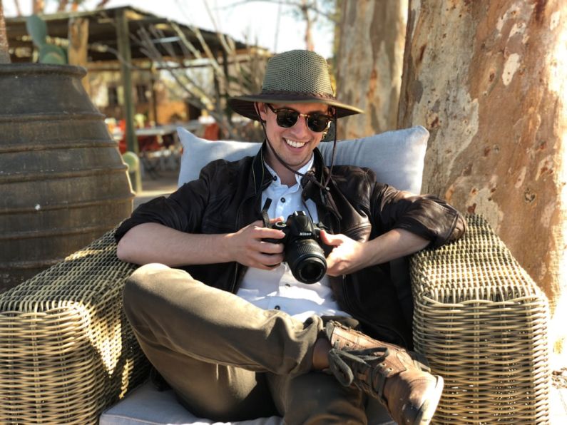 Traveler - man sitting on chair while holding camera