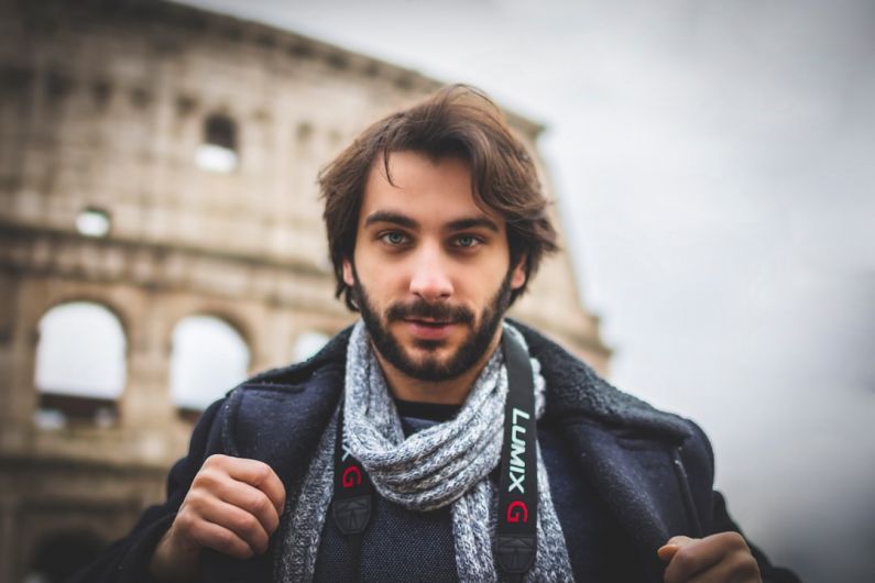 Traveler - man wearing black jacket standing near Colosseum