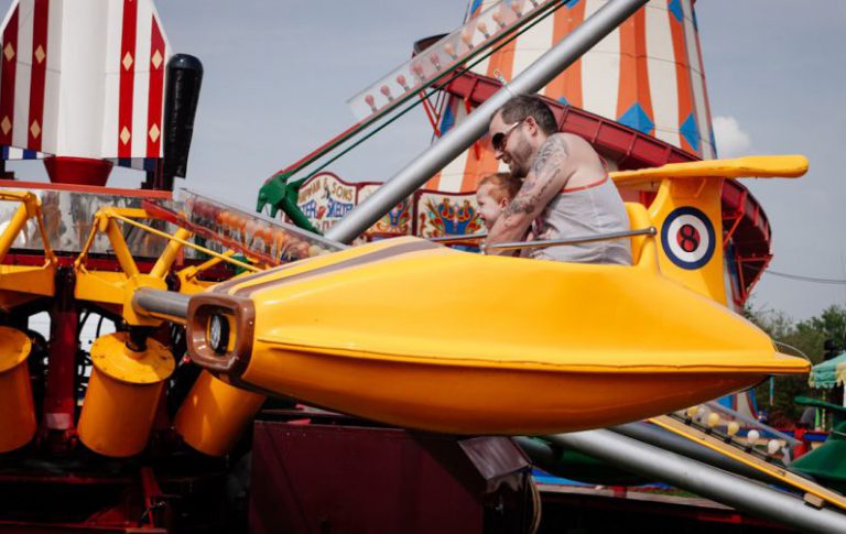 Family Fun - man with child riding on amusement ride