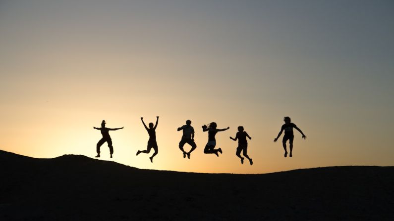 Family Fun - six silhouette of people jumping during sunrise