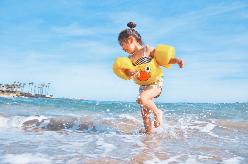 Family Fun - girl playing beside body of water during daytime