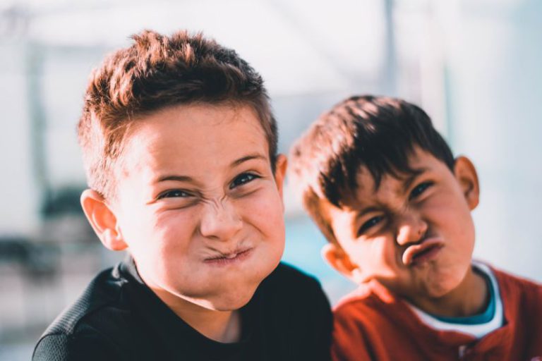 Family Fun - shallow focus photography of two boys doing wacky faces