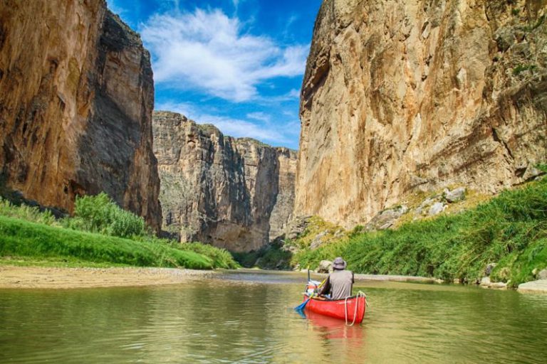 Texas - man in gray top sailing with red canoe boat during daytime