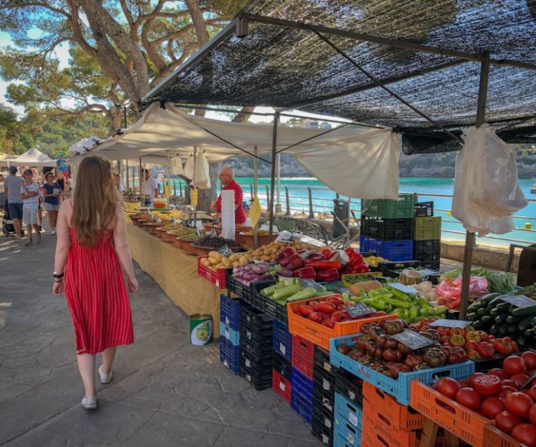 Farmers Market - woman walking beside fruit and vegetable vendors